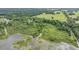 Aerial image captures a property with a blend of verdant trees, grassy meadows, and a peaceful body of water at 1611 County Road 753S, Webster, FL 33597