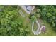 Overhead view features a home, pond, and an outbuilding with parking all connected by a winding driveway on a tree-filled lot at 1611 County Road 753S, Webster, FL 33597