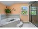 Bathroom with soaking tub, walk-in shower, and peach colored walls with a window view at 1611 County Road 753S, Webster, FL 33597