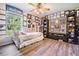 Charming bedroom featuring a daybed, wood floors, and large window with many awards on display at 1611 County Road 753S, Webster, FL 33597