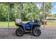 Carport view with a blue all-terrain vehicle and tractor equipment for property maintenance at 1611 County Road 753S, Webster, FL 33597