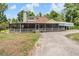 Charming home with large screened porch and adjacent covered parking area on a graveled drive at 1611 County Road 753S, Webster, FL 33597