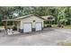 Spacious two-car garage with additional covered parking and graveled driveway on a wooded lot at 1611 County Road 753S, Webster, FL 33597