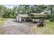 Aerial view displaying a large garage with multiple doors, additional lean-to storage, and parked equipment at 1611 County Road 753S, Webster, FL 33597