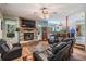 Bright living room featuring a stone fireplace, a ceiling fan, and cozy seating arrangements at 1611 County Road 753S, Webster, FL 33597