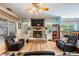 Bright living room showcasing the stone fireplace, ceiling fan, and large windows for natural light at 1611 County Road 753S, Webster, FL 33597