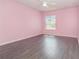 Bright bedroom with sleek wood flooring, a ceiling fan, and a window enhancing the room's cozy ambiance at 239 Beacon Pointe Dr, Ocoee, FL 34761