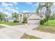 Beautiful exterior elevation with palm trees, manicured lawn, and brick-paved driveway at 239 Beacon Pointe Dr, Ocoee, FL 34761