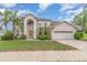 Stunning two-story home featuring a stucco facade, arched entry, and lush landscaping at 239 Beacon Pointe Dr, Ocoee, FL 34761