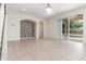 Bright living room featuring neutral tile flooring, modern lighting fixture, and a slider to the backyard at 239 Beacon Pointe Dr, Ocoee, FL 34761