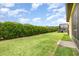 View of the backyard with lush lawn, privacy hedge, patio and screened lanai at 472 Pontevedra Rd, Davenport, FL 33837