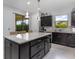 Open kitchen featuring dark cabinets, granite countertops, stainless steel appliances, and access to the backyard at 472 Pontevedra Rd, Davenport, FL 33837