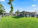 Expansive backyard with green lawn, shed, and screened patio, perfect for outdoor activities at 718 Cr 467, Lake Panasoffkee, FL 33538