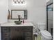 Bathroom with a dark vanity, vessel sink, and shower featuring glass doors and green accents at 718 Cr 467, Lake Panasoffkee, FL 33538
