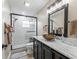 Updated bathroom with glass shower, dark cabinets, marble counters, and modern fixtures at 718 Cr 467, Lake Panasoffkee, FL 33538