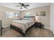 Well-lit bedroom featuring a queen-sized bed, beach-themed artwork, and wood-look floors at 718 Cr 467, Lake Panasoffkee, FL 33538