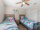 Cozy bedroom featuring two twin beds, wood-look floors, and closet at 718 Cr 467, Lake Panasoffkee, FL 33538