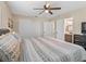 Bedroom featuring wood-look floors, a ceiling fan, ensuite access, and a large closet at 718 Cr 467, Lake Panasoffkee, FL 33538