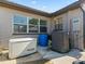 Exterior back of the home featuring a backup generator, AC unit, and multiple windows at 718 Cr 467, Lake Panasoffkee, FL 33538