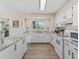 Bright kitchen featuring white cabinets, modern appliances, and views of the backyard at 718 Cr 467, Lake Panasoffkee, FL 33538