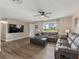 Cozy living room with modern furnishings, sleek flooring, and a large window with bright natural light at 718 Cr 467, Lake Panasoffkee, FL 33538