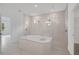 Bright bathroom featuring a luxurious tub, glass enclosed shower, and tile flooring at 12898 Harvest Rain Ave, Winter Garden, FL 34787