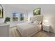 A bright bedroom features a luxurious upholstered headboard and beautiful outdoor views at 12898 Harvest Rain Ave, Winter Garden, FL 34787