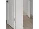 Hallway shows entry into a room, with white doors, and wood laminate flooring at 12898 Harvest Rain Ave, Winter Garden, FL 34787