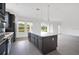 Modern kitchen features gray cabinets, stainless steel appliances, island, and water views at 12898 Harvest Rain Ave, Winter Garden, FL 34787