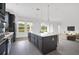 Modern kitchen features gray cabinets, stainless steel appliances, and opens to living area at 12898 Harvest Rain Ave, Winter Garden, FL 34787