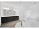 Luxurious bathroom with a soaking tub, double vanity, and large mirror with contemporary lighting at 12898 Harvest Rain Ave, Winter Garden, FL 34787