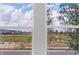 Exterior view of a landscape, with clear blue skies seen through a double window at 12898 Harvest Rain Ave, Winter Garden, FL 34787