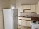Cozy kitchen with a double sink, upper cabinets, and a full-sized refrigerator at 2915 Winter Lake Rd, Lakeland, FL 33803