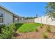 Backyard featuring exterior view of home, lush grass, mulch, privacy fence, and shrubbery at 5920 Bristle Oak St, Mount Dora, FL 32757