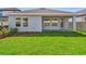 Backyard featuring exterior view of home, lush grass, mulch, and covered patio at 5920 Bristle Oak St, Mount Dora, FL 32757