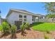 Backyard featuring exterior view of home, lush grass, mulch, and bushes at 5920 Bristle Oak St, Mount Dora, FL 32757
