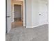 Carpeted room featuring two white doors, neutral paint, and view into tiled hallway at 5920 Bristle Oak St, Mount Dora, FL 32757