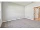 A neutral bedroom with carpet, a side window, and a doorway leading to the bathroom at 5920 Bristle Oak St, Mount Dora, FL 32757