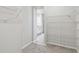 Spacious carpeted walk-in closet featuring wire shelving and view into ensuite bathroom at 5920 Bristle Oak St, Mount Dora, FL 32757