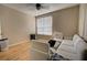 Bright bedroom with natural light showcasing hardwood floors, a modern design and white couch for relaxation at 6300 Raleigh St # 102, Orlando, FL 32835