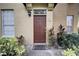 Inviting front door with a keypad, lush plants, and exterior lighting creating a warm entry to the home at 6300 Raleigh St # 102, Orlando, FL 32835