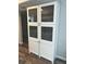 Tall white shelving unit with a patterned design in the glass panels for storage at 730 Barber Cir, Lakeland, FL 33803