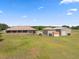Aerial view of the property featuring a home with a screened porch, two garages, and a spacious yard at 14365 Evans Ranch Rd, Lakeland, FL 33809