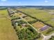 Scenic aerial view with houses, vast fields, and tree-lined roads, showing the property's location in a quiet, countryside setting at 14365 Evans Ranch Rd, Lakeland, FL 33809
