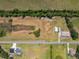 Aerial view of property featuring outbuildings, expansive cleared fields, and a long private driveway at 14365 Evans Ranch Rd, Lakeland, FL 33809