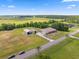 Spacious property with lush green fields, featuring a house and separate outbuildings under a beautiful blue sky at 14365 Evans Ranch Rd, Lakeland, FL 33809