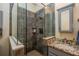 Close-up of a modern shower with glass doors, stone tile and niche, and a granite countertop sink at 14365 Evans Ranch Rd, Lakeland, FL 33809