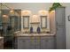 Elegant bathroom with a double sink vanity, granite countertops, stylish mirrors, and tiled walk-in shower at 14365 Evans Ranch Rd, Lakeland, FL 33809
