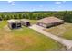 View of home with multiple outbuildings, a long driveway, and generous green space, ideal for hobbies and storage at 14365 Evans Ranch Rd, Lakeland, FL 33809