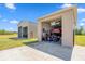 Large garage with two bays, one housing a car on a lift and the other filled with tools and equipment at 14365 Evans Ranch Rd, Lakeland, FL 33809